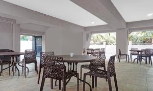 ein Esszimmer mit Tischen, Stühlen und Fenstern in der Unterkunft Treebo Trend Atithi Corporate Stay Baner Baner IT Hub in Pune