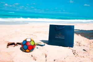 Retal View North Coast Aqua Park في العلمين: كرة قدم ونظارة شمسية على الشاطئ مع حقيبة