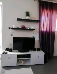 ein weißes Entertainment-Center mit einem Flachbild-TV in der Unterkunft Apartman Maslineo in Maslinica