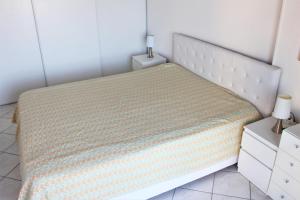 - une chambre avec un lit blanc et une couverture jaune dans l'établissement GOELETTES 311, à Saint-Cyprien