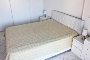 a bedroom with a white bed with a yellow blanket at GOELETTES 311 in Saint-Cyprien