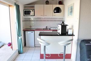 eine kleine Küche mit einer Theke und 2 Hockern in der Unterkunft GOELETTES 311 in Saint-Cyprien