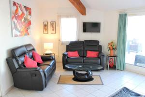 a living room with two leather chairs and a table at GOELETTES 311 in Saint-Cyprien