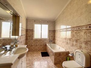 y baño con lavabo, bañera y aseo. en Vila Feliz, en Paul do Mar