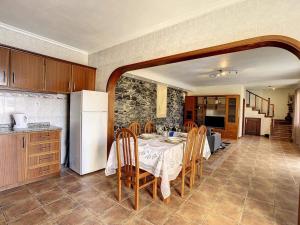 a kitchen with a table with chairs and a refrigerator at Vila Feliz in Paul do Mar