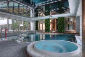 a large pool with a hot tub in a building at Luxury Del Sol Apartments Świnoujście in Świnoujście