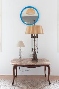 a table with a lamp and a mirror on a wall at Biennale Giardini in Venice