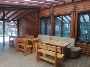 a wooden cabin with a table and chairs on a deck at Къща за гости ЕКО in Tsigov Chark