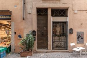 a building with a door with a plant in front of it at iFlat Charming Apartment near Piazza Venezia in Rome