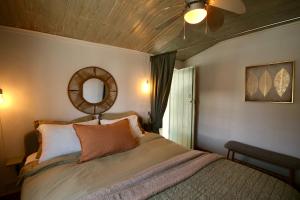 a bedroom with a bed with a mirror and a ceiling fan at Casa Nórdica in Chão de Lamas +15 photos