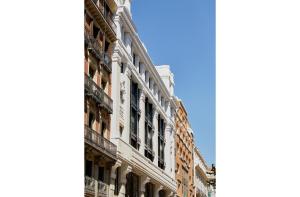 un edificio blanco alto con ventanas en una calle en 60 Balconies Iconic en Madrid