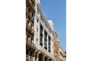 um edifício branco alto com janelas numa rua em 60 Balconies Iconic em Madri