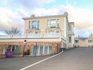 a large house with a fence in front of it at Cottage 1 Newcourt in Torquay