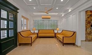 a waiting room with two chairs and a ceiling fan at Treebo Trend Chandraprasth Residency in Nagpur