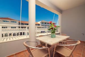 a table and chairs on a balcony with a view of a building at Avouris 2 Bedroom Apartment & Studios in Plános