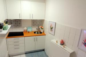Una pequeña cocina con gabinetes blancos y un fregadero. en Apartments Center Alfama II, en Lisboa