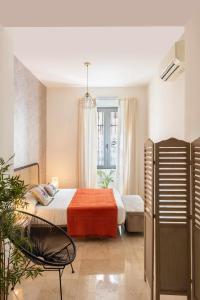 sypialnia z łóżkiem, krzesłem i oknem w obiekcie MonKeys Apartments Loft Pureza w Sewilli