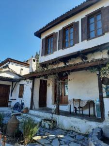 Una casa vieja con una silla delante. en Nikbin Yamaç Pansiyon en Selcuk