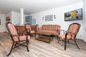 a living room with three chairs and a couch at Hotel-Pension Janssen - Gästehaus Huus an't Deep in Neuharlingersiel