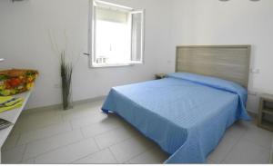 - une chambre avec un lit bleu et une fenêtre dans l'établissement VIRGOLA ZERO HOLIDAY BEACH, à Porto Potenza Picena