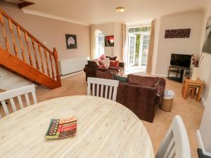ein Wohnzimmer mit einem Tisch und einem Sofa in der Unterkunft No 1 Railway Cottages in Betws-y-coed