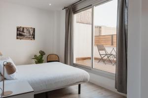 A bed or beds in a room at Apartamentos Espai Progres by Be Barcelona