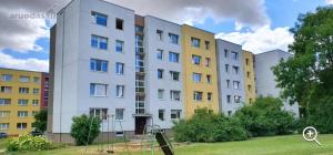 a group of buildings in a park with a grass field at Cozy 3 bedroom apartament in town centre of Joniškis in Joniškis