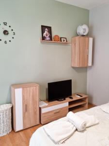a room with a bed, television and a dresser at Tirana City Centre Folk Villa in Tirana