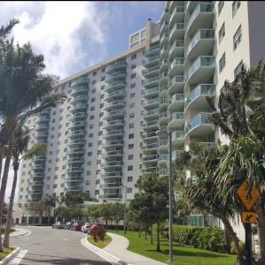duży budynek apartamentowy przy ulicy z palmami w obiekcie Miami Sunny Isles ocean reserve 704 w Miami