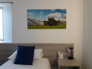 a bed with a blue pillow and a picture on the wall at Broadview Lodge in Norwich