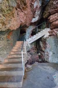 una scala che conduce in una grotta con una scogliera di Casa con piscina, vistas y acceso privado al mar. Vistes Voramar. a Cala en Blanes