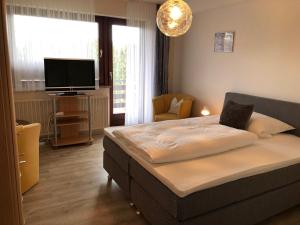 a bedroom with a bed and a flat screen tv at Pension Dabrunz in Heimbach
