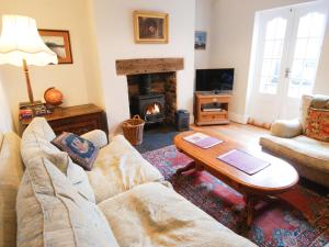 a living room with a couch and a table and a fireplace at 2 Ashby Place in Chester