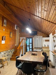 a dining room with a large wooden table and chairs at Cabana din Poveste Valea Doftanei in Trăisteni