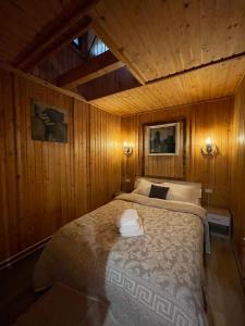 a bedroom with a bed in a wood paneled room at Cabana din Poveste Valea Doftanei in Trăisteni