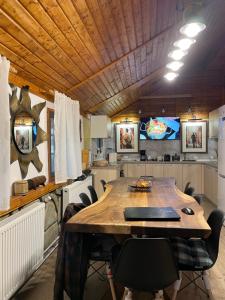 a kitchen with a large wooden table and chairs at Cabana din Poveste Valea Doftanei in Trăisteni