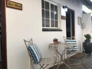 a patio with a table and chairs and a window at Cornerstone Bed and Breakfast Kroonstad in Kroonstad