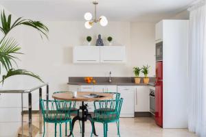 MonKeys Apartments Luxury Penthouse Pureza & Chill Out في إشبيلية: مطبخ مع طاولة وكراسي وثلاجة حمراء