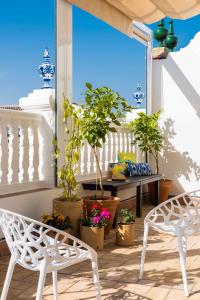 einen Balkon mit einem Tisch, Stühlen und Topfpflanzen in der Unterkunft MonKeys Apartments Luxury Penthouse Pureza & Chill Out in Sevilla