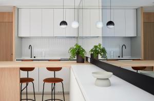 a kitchen with white cabinets and wooden stools at 60 Balconies Iconic in Madrid