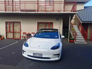 un coche blanco estacionado frente a una casa en 555 Motel Dunedin en Dunedin
