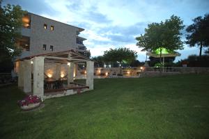 a large building with a yard with a grass field at Panorama Siviris in Siviri