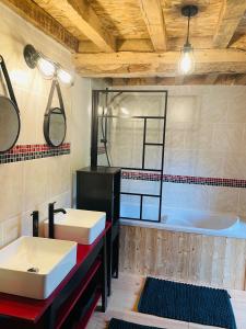 Tournebu的住宿－Grange à grains à l'Ombre d'une Tour，浴室配有两个盥洗盆和浴缸。
