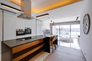 een keuken met een aanrecht en een klok aan de muur bij Luxury Apartment with Valletta and Harbour Views in Sliema