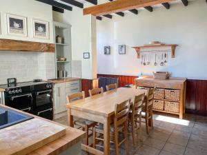 - une cuisine avec une table et des chaises en bois dans l'établissement The Farmhouse, à Whitby