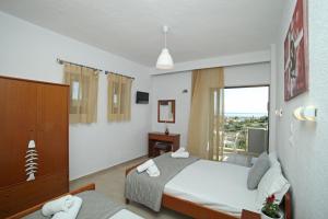 a hotel room with a bed and a window at Panorama Siviris in Siviri