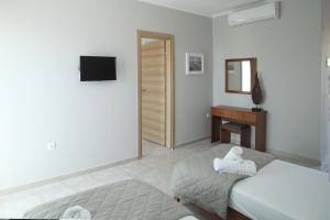 a bedroom with two beds and a desk and a mirror at Panorama Siviris in Siviri