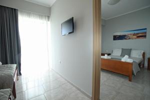 a living room with a couch and a tv on a wall at Panorama Siviris in Siviri