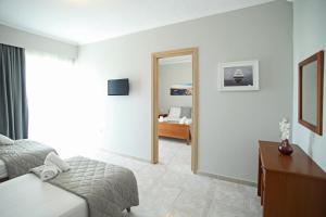 a hotel room with a bed and a mirror at Panorama Siviris in Siviri