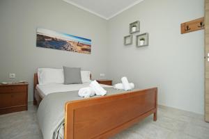 a bedroom with a bed with two stuffed animals on it at Panorama Siviris in Siviri